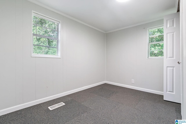 unfurnished room with crown molding and dark carpet