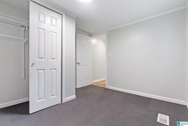 unfurnished bedroom featuring carpet, ornamental molding, and a closet