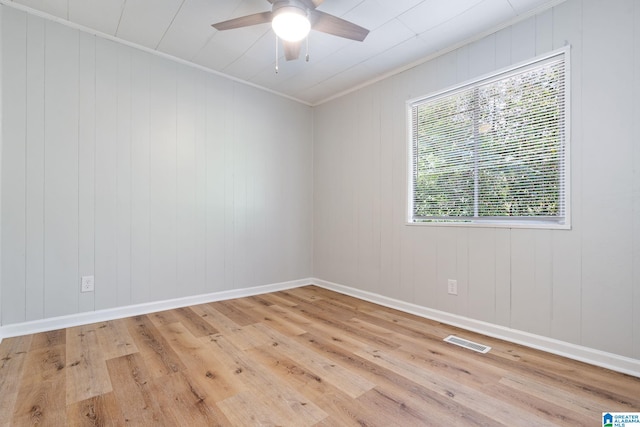 unfurnished room with crown molding, a wealth of natural light, ceiling fan, and light hardwood / wood-style floors