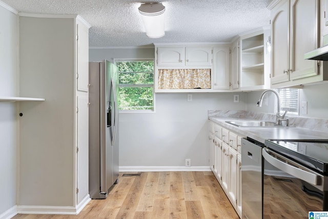 kitchen featuring stainless steel appliances, sink, light wood-type flooring, and white cabinets