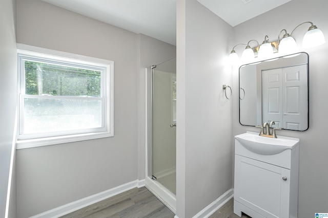 bathroom with vanity, hardwood / wood-style flooring, and a shower with door