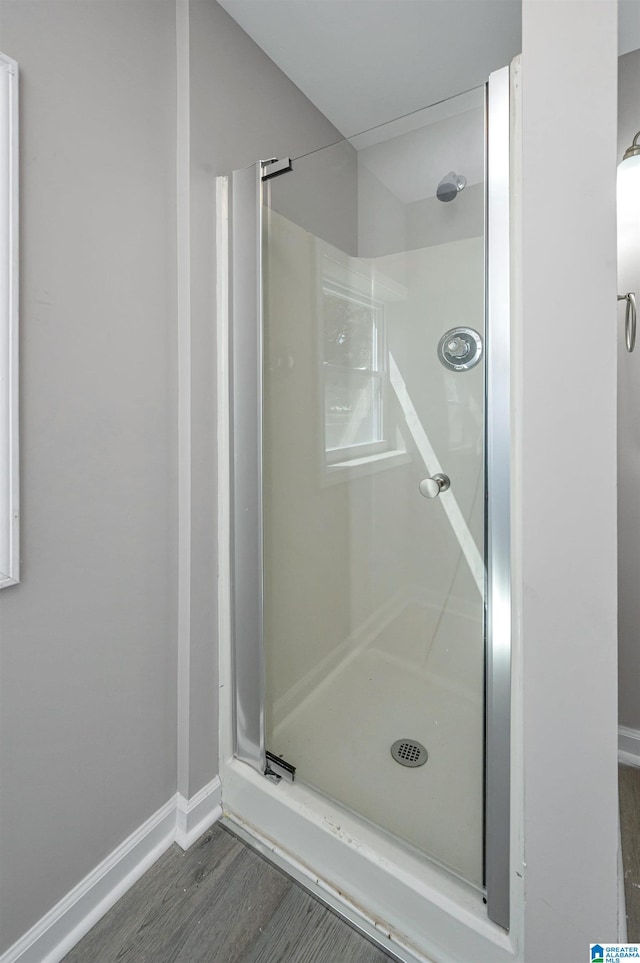 bathroom featuring hardwood / wood-style floors and a shower with shower door