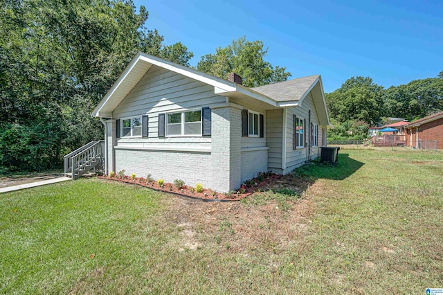 view of front of property with central AC unit and a front lawn