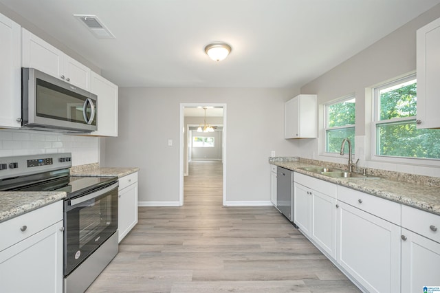 kitchen with light hardwood / wood-style flooring, stainless steel appliances, sink, and white cabinets