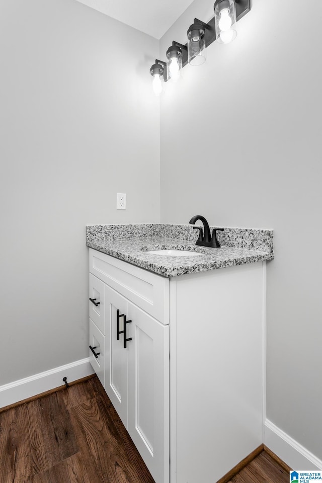 bathroom featuring vanity, baseboards, and wood finished floors