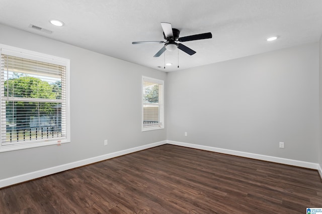 spare room featuring dark wood-type flooring and ceiling fan