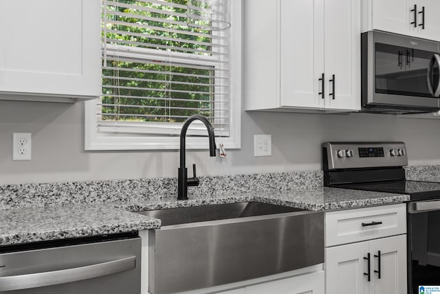 kitchen featuring white cabinetry, a healthy amount of sunlight, stainless steel appliances, and sink