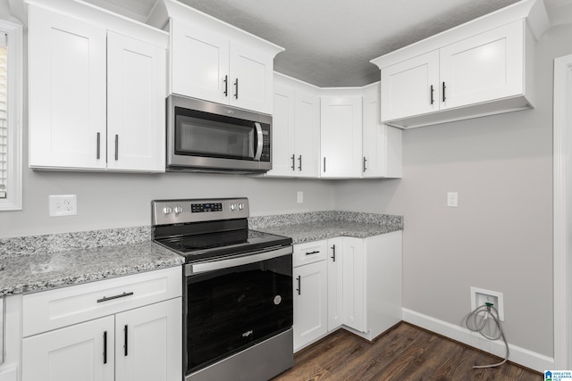 kitchen featuring appliances with stainless steel finishes, light stone countertops, and white cabinetry