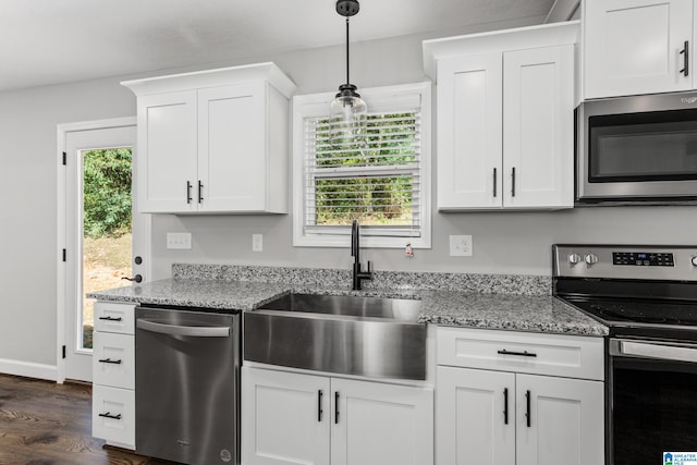 kitchen with a healthy amount of sunlight, sink, decorative light fixtures, and appliances with stainless steel finishes