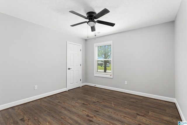 empty room with ceiling fan and dark hardwood / wood-style flooring