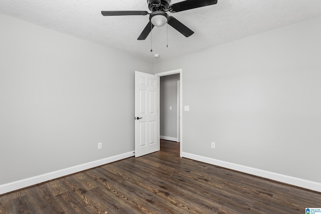 empty room with dark wood-type flooring, a textured ceiling, and ceiling fan