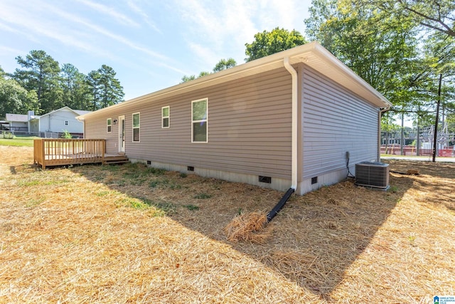 view of side of property with central air condition unit and a deck