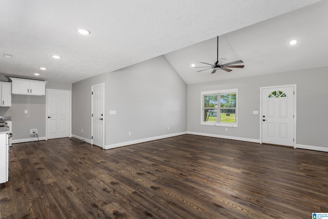 unfurnished living room featuring a textured ceiling, dark hardwood / wood-style flooring, vaulted ceiling, and ceiling fan