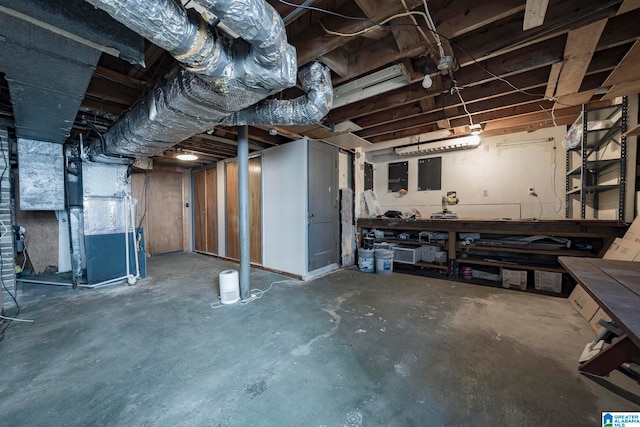 basement with a workshop area and heating unit