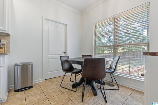 dining space with crown molding and light tile patterned flooring