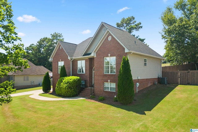 view of front of house with central AC unit and a front lawn