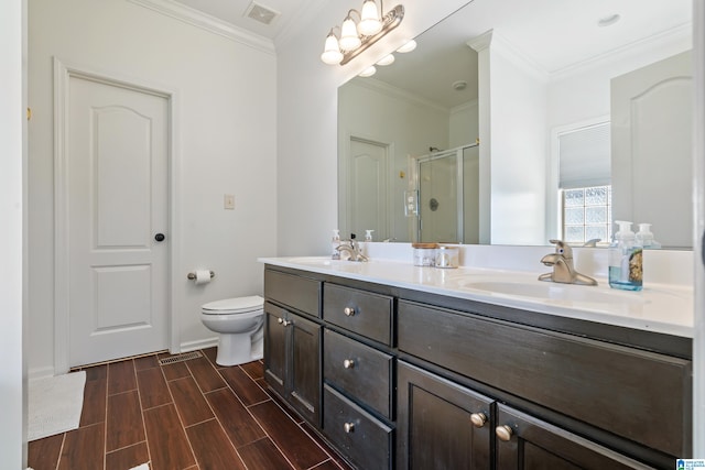 bathroom with a shower with door, vanity, wood-type flooring, crown molding, and toilet