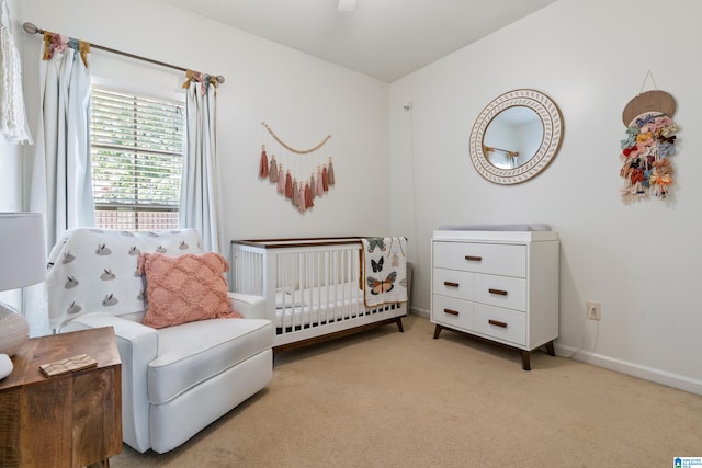 carpeted bedroom featuring a crib