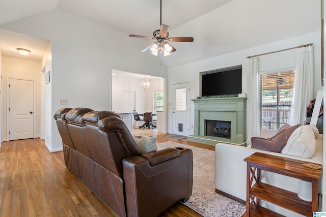 living room with ceiling fan, hardwood / wood-style flooring, and vaulted ceiling