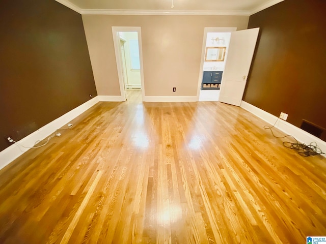 empty room with crown molding and hardwood / wood-style flooring