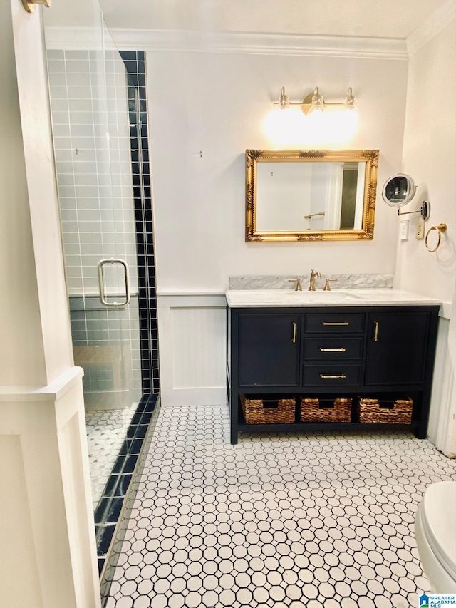 bathroom featuring a shower with door, vanity, toilet, and ornamental molding