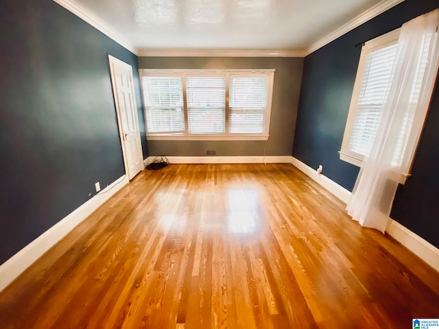 unfurnished room featuring ornamental molding and wood-type flooring