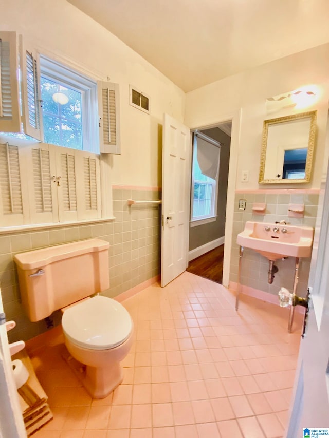 bathroom with tile walls, toilet, sink, and tile patterned floors