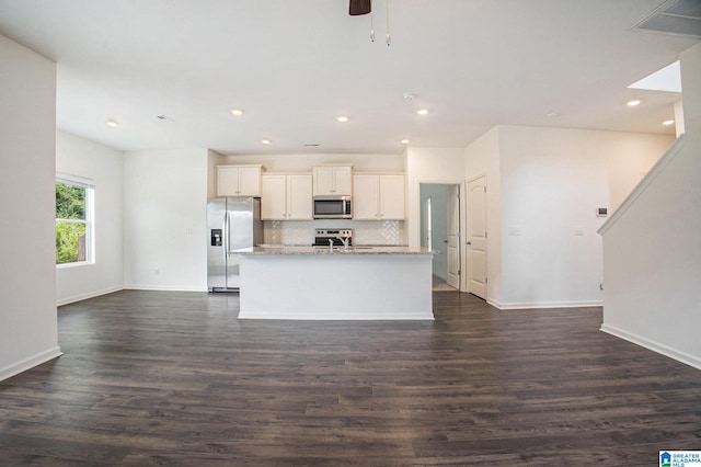 kitchen featuring ceiling fan, stainless steel appliances, dark hardwood / wood-style floors, and a center island with sink