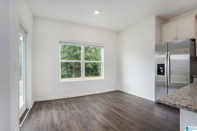 unfurnished dining area featuring dark hardwood / wood-style flooring and plenty of natural light