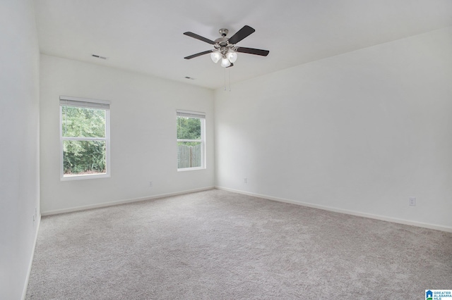 carpeted spare room featuring ceiling fan