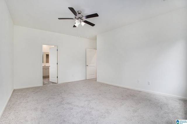 spare room featuring light colored carpet and ceiling fan