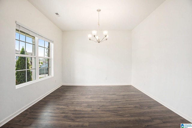 unfurnished room featuring dark wood-type flooring and an inviting chandelier