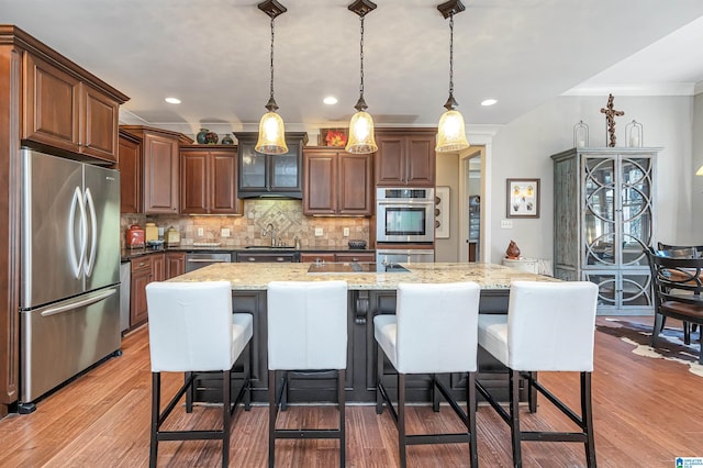 kitchen with pendant lighting, appliances with stainless steel finishes, dark wood-type flooring, and crown molding