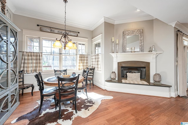 dining space featuring an inviting chandelier, crown molding, and hardwood / wood-style flooring