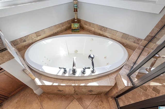 bathroom featuring tile patterned floors and a relaxing tiled tub