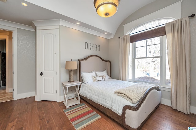 bedroom featuring dark hardwood / wood-style floors, vaulted ceiling, and multiple windows