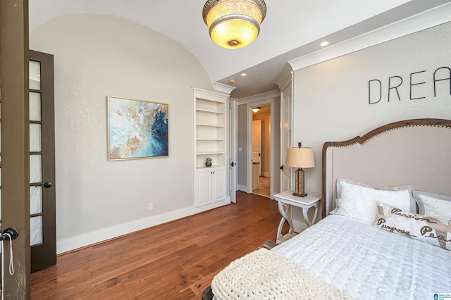 bedroom with vaulted ceiling and dark wood-type flooring