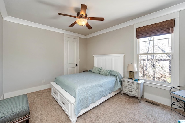 carpeted bedroom featuring ornamental molding, ceiling fan, and multiple windows