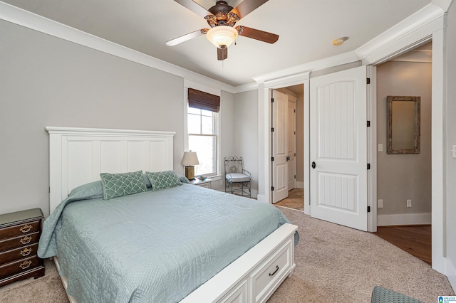 carpeted bedroom with ceiling fan and crown molding