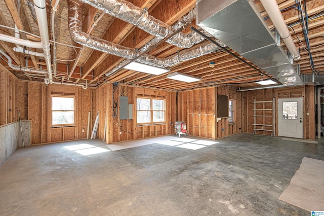 miscellaneous room featuring electric panel and concrete floors