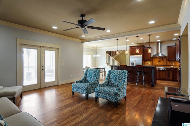 living room with french doors, ceiling fan with notable chandelier, plenty of natural light, and dark wood-type flooring