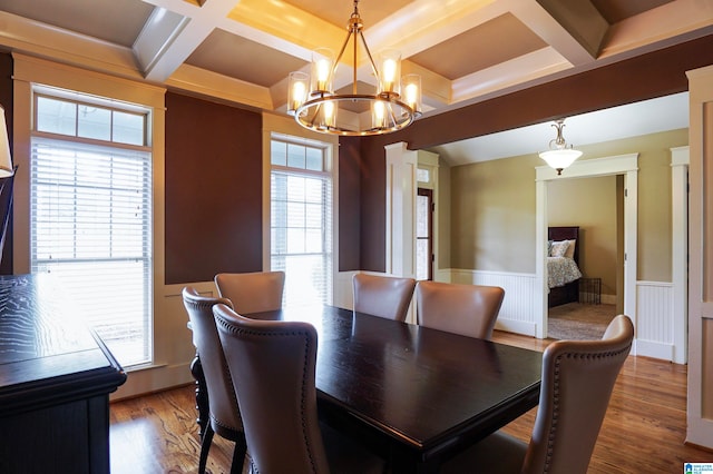 dining area featuring beam ceiling, a wealth of natural light, a notable chandelier, and hardwood / wood-style flooring