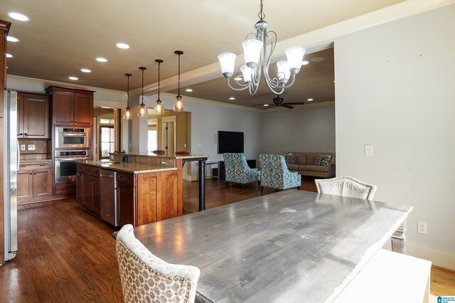 dining area featuring sink, dark hardwood / wood-style floors, crown molding, and ceiling fan with notable chandelier