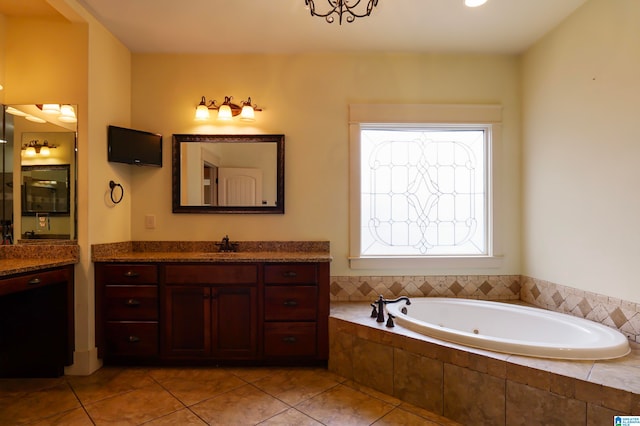 bathroom with tile patterned flooring, a relaxing tiled tub, and vanity