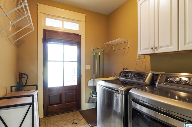 laundry area featuring cabinets, light tile patterned floors, washing machine and dryer, and a healthy amount of sunlight