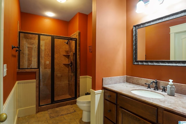 bathroom with toilet, tile patterned flooring, vanity, and walk in shower