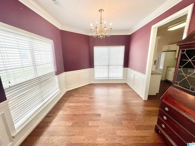 dining room with a wealth of natural light, light wood-type flooring, and a textured ceiling