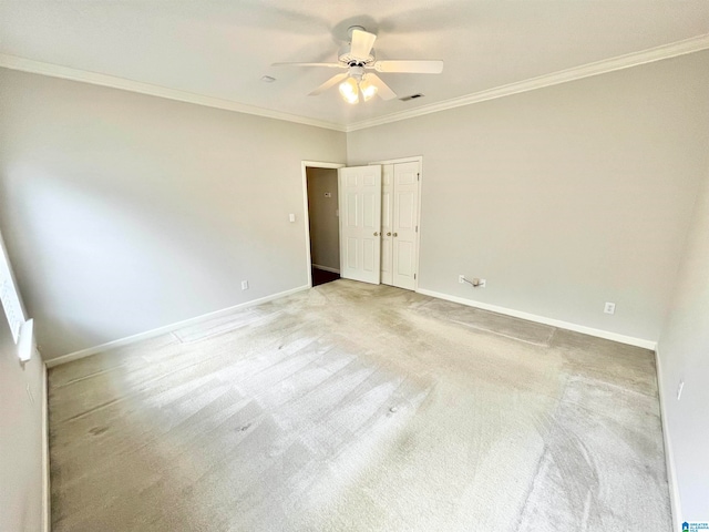 carpeted empty room with crown molding and ceiling fan