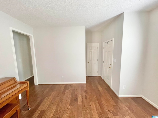 unfurnished room with a textured ceiling and light hardwood / wood-style floors