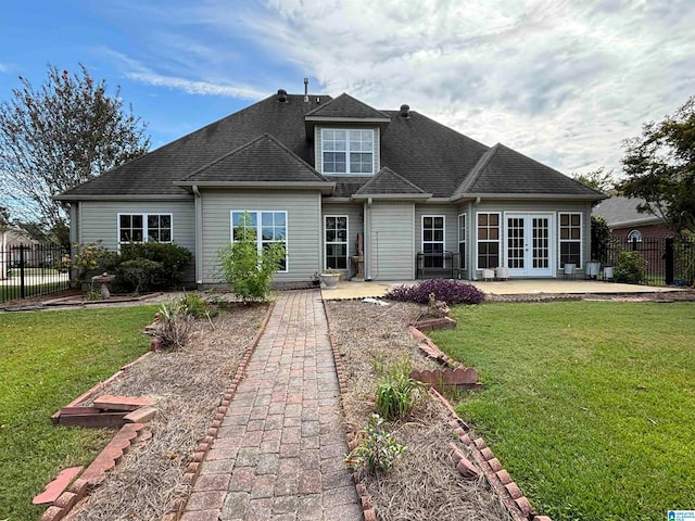 back of property with french doors, a lawn, and a patio area